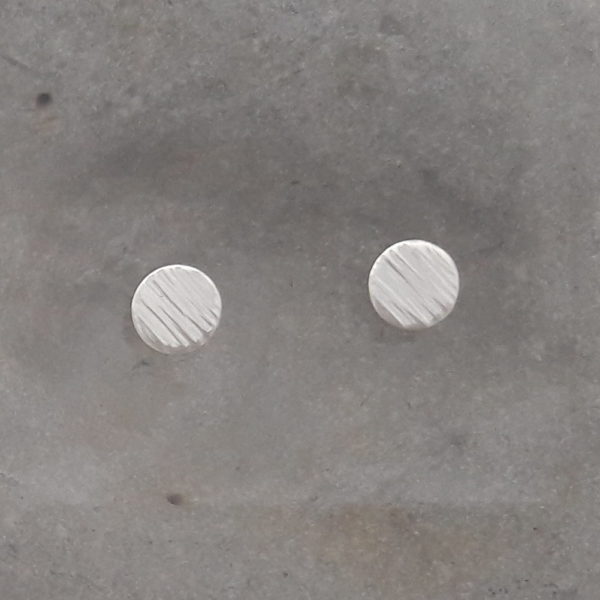 Randigt mönstrade silverörhängen mot grå bakgrund. Görs i tre storlekar, 8, 10 och 12 mm.